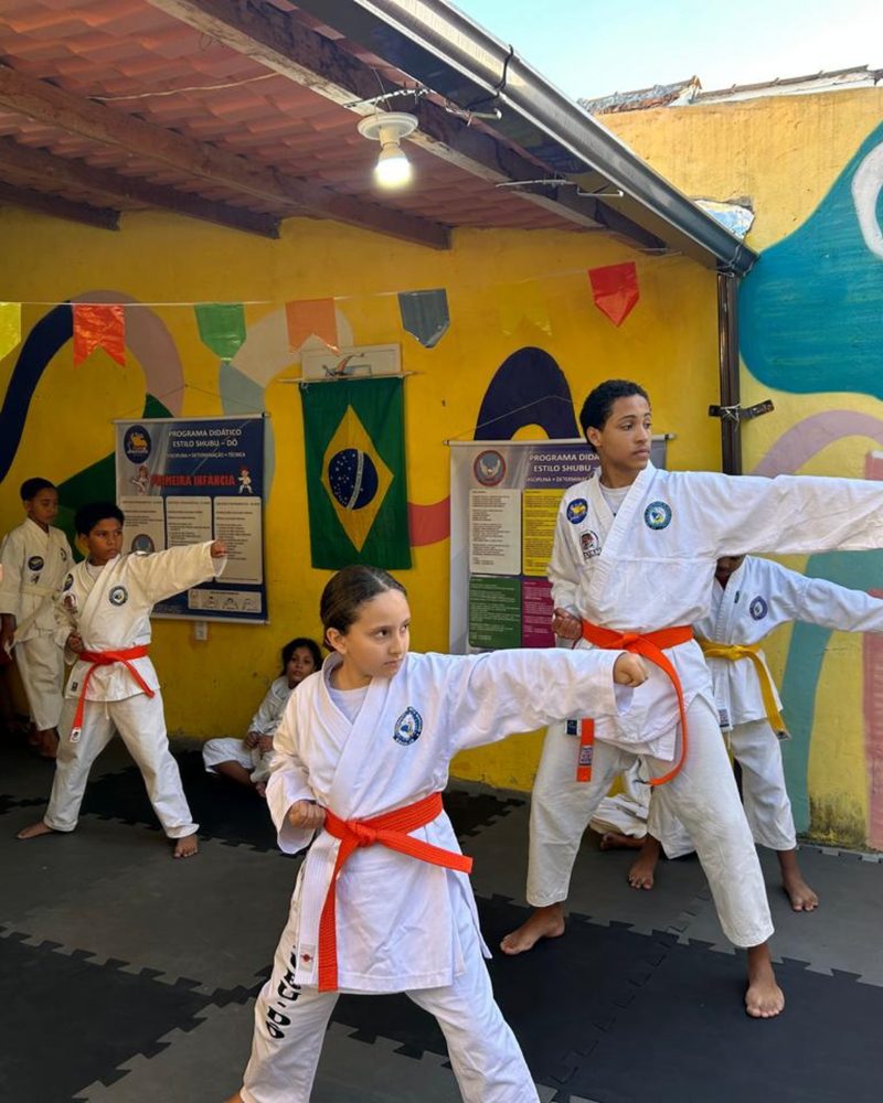 Crianças de quimono treinando karatê no pátio da Casa Amarela
