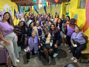 Grupo de mulheres reunidas e sorrindo no encontro do Quinta Delas