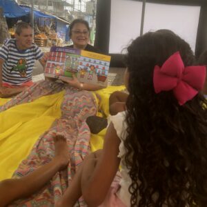 Educadora e menina lendo juntas, de perto